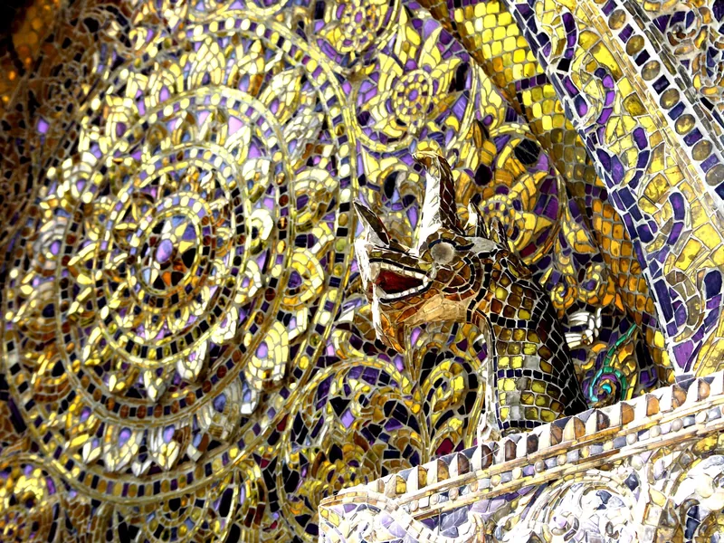 Intricate mirrored mosaic and dragon figure adorn a temple wall at Wat Xieng Thong in Luang Prabang. Intricate mirrored mosaic and dragon figure adorn a temple wall at Wat Xieng Thong in Luang Prabang.