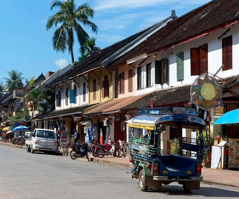 A tuk-tuk parked along a colonial-era street lined with shophouses in Luang Prabang. A tuk-tuk parked along a colonial-era street lined with shophouses in Luang Prabang.