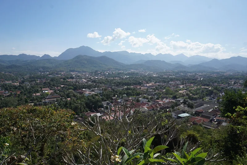 Panoramic view of Luang Prabang town surrounded by misty mountains, seen from a hilltop viewpoint. Panoramic view of Luang Prabang town surrounded by misty mountains, seen from a hilltop viewpoint.